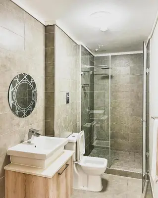 a bathroom with a toilet and a sink and a shower at Modern One Bedroom Apartment Next to Canal Walk Mall in Cape Town