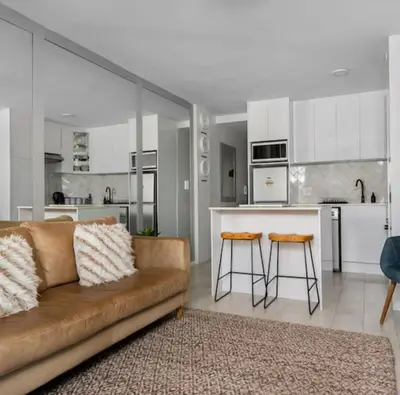 a living room with a couch and a kitchen at JC Mountain View in Cape Town