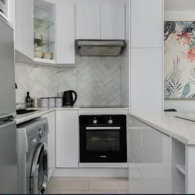 a white kitchen with a dishwasher and a washer at JC Mountain View in Cape Town