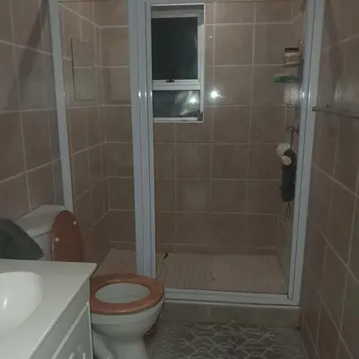 a bathroom with a shower with a toilet and a sink at Cozy Corner in Cape Town