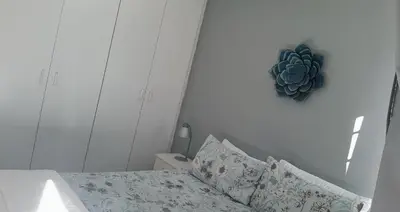 a bedroom with a bed and a plant on the wall at Cozy Corner in Cape Town