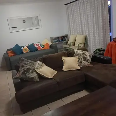 a living room with a brown couch with pillows at Cozy Corner in Cape Town