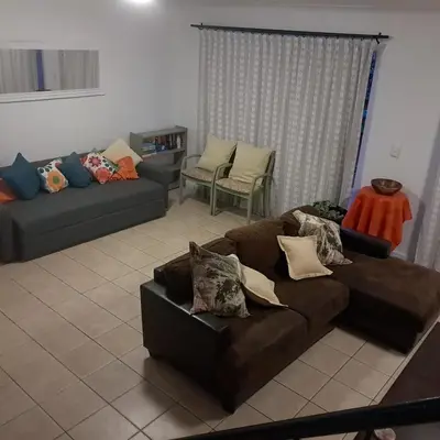 a living room with a brown couch and a chair at Cozy Corner in Cape Town