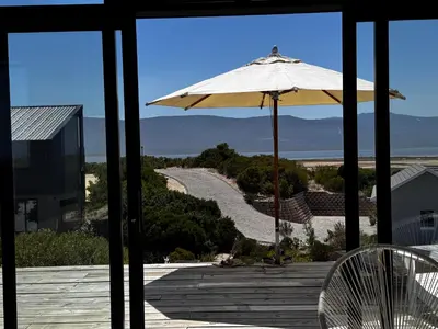 a patio with an umbrella and a view of a road at Lagoon & beach paradise in Lake Marina