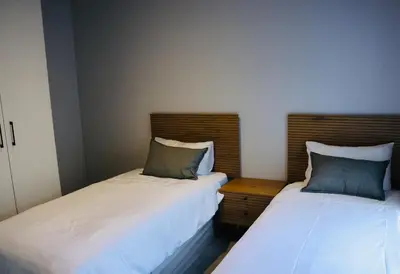two beds sitting next to each other in a room at 21b on SANDOWN in Cape Town