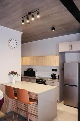 a kitchen with a counter and a clock on the wall at 21b on SANDOWN in Cape Town