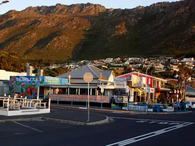 a street in a town with a mountain in the background at Sea Urchin in Gordonʼs Bay
