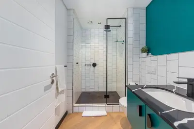a bathroom with a shower and a sink and a toilet at Nine Palms - Century City Luxury Apartment in Cape Town