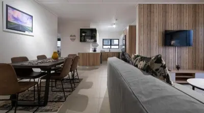 a living room with a couch and a dining room at #AlimamaSpaces Manson's Fynbos Villa in Cape Town