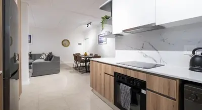 a kitchen and living room with a stove top oven at #AlimamaSpaces Manson's Fynbos Villa in Cape Town