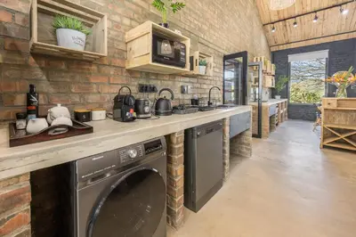 a kitchen with a washer and dryer under a counter at My Venue at Avemore in Onder-Papegaaiberg