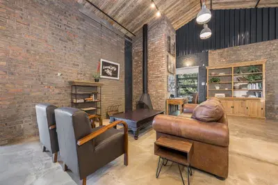 a living room with a brick wall and a couch and a table at My Venue at Avemore in Onder-Papegaaiberg