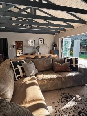 a living room with a brown leather couch at Pool & Garden Winelands Retreat in Stellenbosch