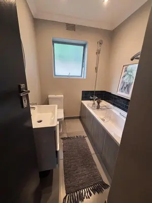 a bathroom with a sink and a tub and a toilet at Pool & Garden Winelands Retreat in Stellenbosch