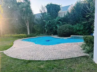 a small swimming pool in a yard next to a house at Pool & Garden Winelands Retreat in Stellenbosch