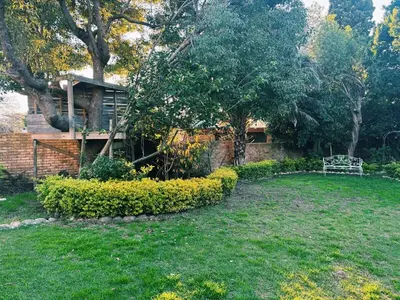 a garden with a bench in front of a house at Pool & Garden Winelands Retreat in Stellenbosch