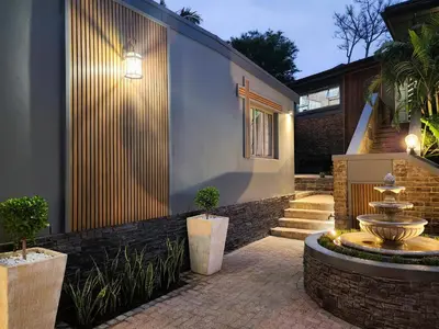 a house with a fountain in front of it at Overflowing Life - Accommodation near Paarl Gim in Paarl