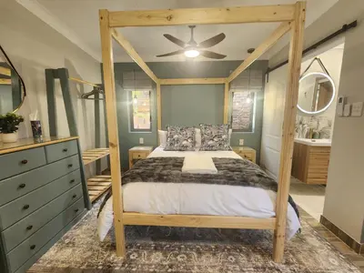a bedroom with a canopy bed and a dresser at Overflowing Life - Accommodation near Paarl Gim in Paarl