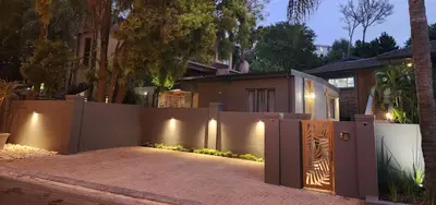 a house with a fence and a gate with lights at Overflowing Life - Accommodation near Paarl Gim in Paarl