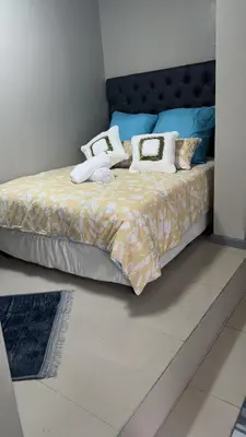 a bedroom with a large bed with pillows on it at Cozy Corner Guest House 25 Harpford avenue wynberg CAPE TOWN WESTERN CAPE in Cape Town