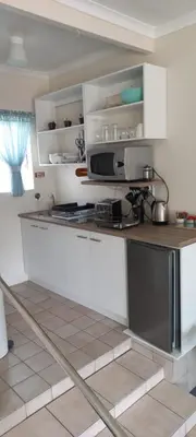 a kitchen with white cabinets and a counter top at Cozy studio flat in Goodwood in Goodwood