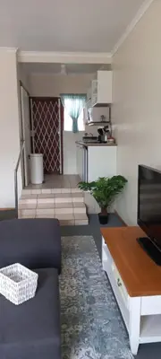 a living room with a couch and a table at Cozy studio flat in Goodwood in Goodwood