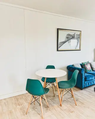a table and chairs in a room with a couch at Shiloh Apartment on Burmeister in Cape Town