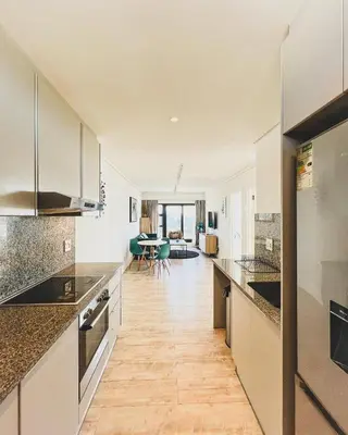 a kitchen with marble counter tops and a dining room at Shiloh Apartment on Burmeister in Cape Town