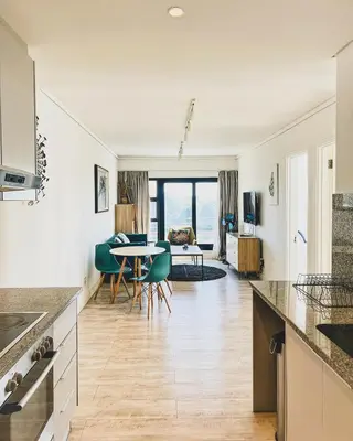 a kitchen with a table and a living room at Shiloh Apartment on Burmeister in Cape Town