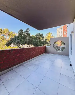 an empty balcony with a brick wall and a window at Spacious 2 bedroom Apt near Canal Walk in Cape Town