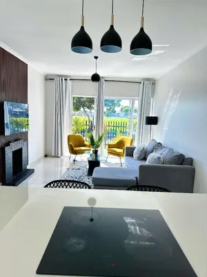 a living room with a couch and a table at Lux Sleek City Haven in Cape Town
