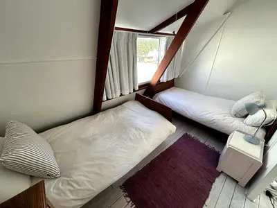 two beds in a small room with a window at Protea Escape - sea, sand and sun on your doorstep in Hermanus
