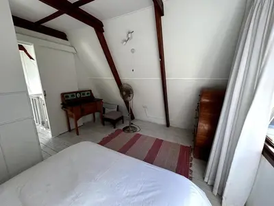 a bedroom with a bed and a desk in a room at Protea Escape - sea, sand and sun on your doorstep in Hermanus