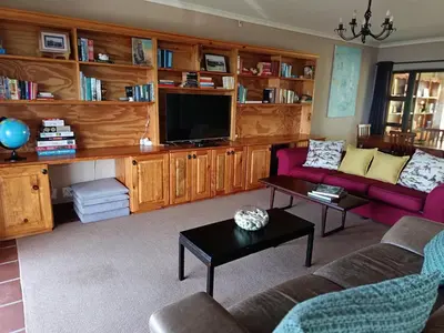 a living room with a couch and a tv at Beautifully Sea View Escape Vermont 5 bedrooms in Hermanus