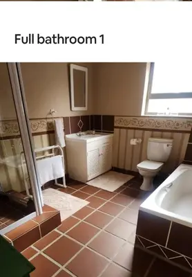 a bathroom with a sink and a toilet and a tub at Beautifully Sea View Escape Vermont 5 bedrooms in Hermanus