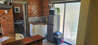 a kitchen with a refrigerator and a brick wall at LyonsDen 1 in Worcester