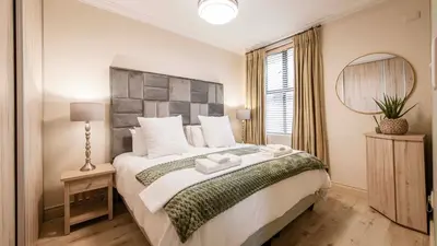 a bedroom with a large bed and a mirror at The Mustard Seed in Stellenbosch