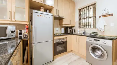 a kitchen with a refrigerator and a washer and dryer at The Mustard Seed in Stellenbosch