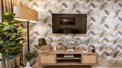 a living room with a tv on a wall at The Mustard Seed in Stellenbosch