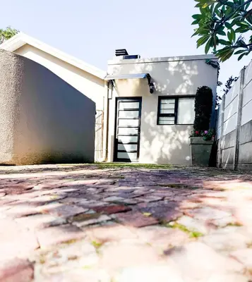 a white house with a door in front of it at Ziminé Cottage in Paarl