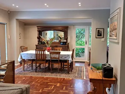 a dining room with a table and a mirror at Spacious Sunny family home in secure leafy sought after area in Stellenbosch