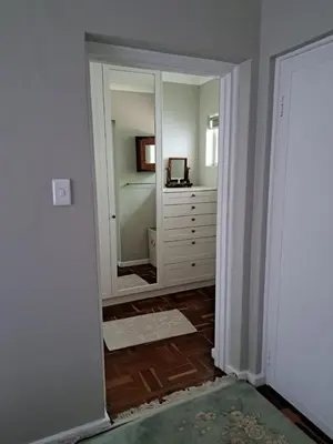 a hallway with a mirror and a dresser in a room at Spacious Sunny family home in secure leafy sought after area in Stellenbosch