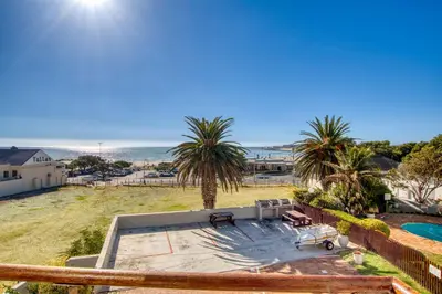 a view of the ocean from the balcony of a house at Ocean & Mountain View Escape, 100m Walk to beach - Gordon's Bay in Gordonʼs Bay