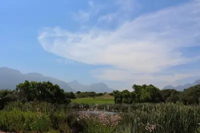 a view of a golf course with mountains in the background at Stellenbosch family villa in Stellenbosch