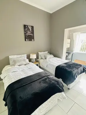 a bedroom with two beds and a window at AAA Luxury Homes in Cape Town
