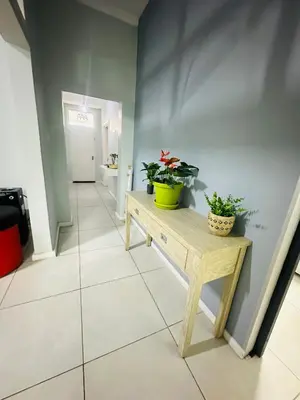 a hallway with two potted plants on a wooden table at AAA Luxury Homes in Cape Town