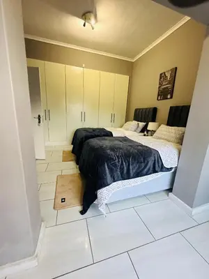 two beds in a room with white tile floors at AAA Luxury Homes in Cape Town