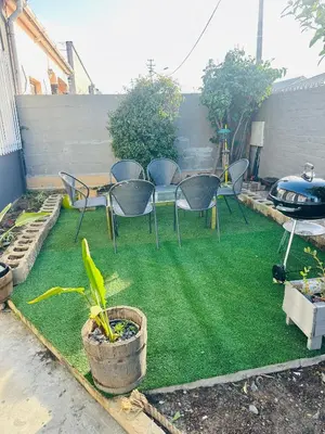 a patio with chairs and a table and grass at AAA Luxury Homes in Cape Town