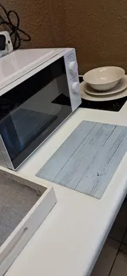 a microwave sitting on a table with a plate at Clay Stone Cottage in Goodwood