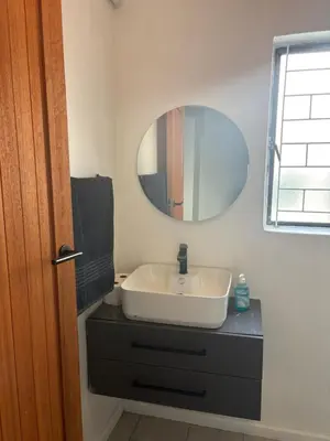 a bathroom with a white sink and a mirror at TLP Haven in Cape Town